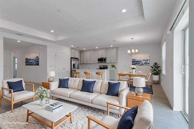 10008 Last Light Gln, Parrish, FL 34219 - living room featuring a raised ceiling, a chandelier, recessed lighting, and light tile patterned floors
