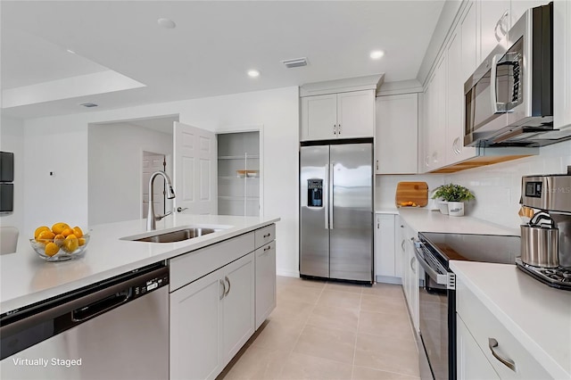10008 Last Light Gln, Parrish, FL 34219 - kitchen with stainless steel appliances, light countertops, white cabinetry, light tile patterned flooring, and tasteful backsplash