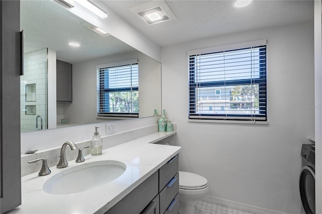 865 Ladyfish Ave Unit C104, New Smyrna Beach, FL 32169 - full bath featuring tile patterned floors, toilet, visible vents, vanity, and washer / dryer