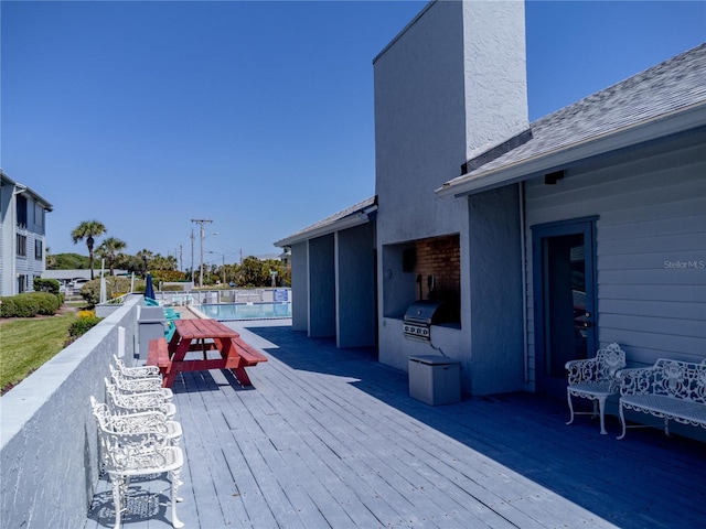 865 Ladyfish Ave Unit C104, New Smyrna Beach, FL 32169 - wooden deck with a grill, a fenced in pool, and area for grilling