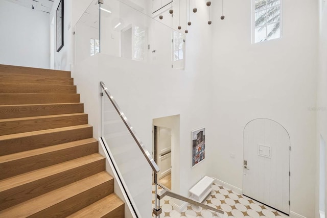 stairs featuring a high ceiling and baseboards