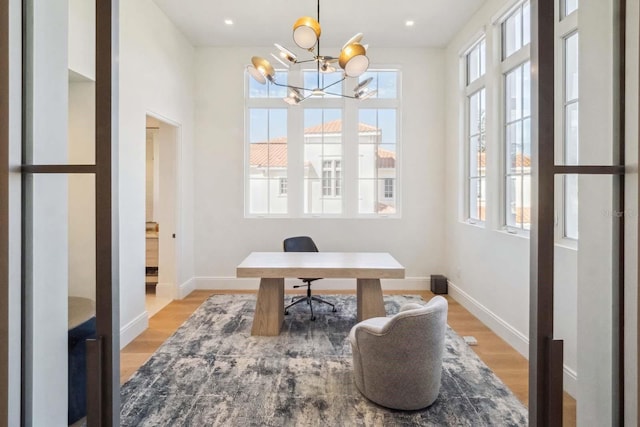 home office featuring a wealth of natural light, baseboards, and light wood-type flooring