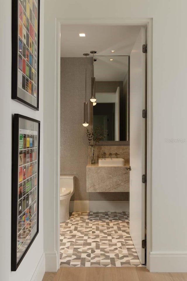 bathroom with tile patterned floors, wine cooler, toilet, baseboards, and vanity