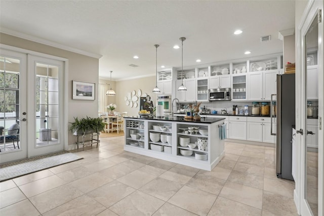 11725 Verrazano Dr, Orlando, FL 32836 - kitchen with appliances with stainless steel finishes, dark countertops, french doors, ornamental molding, and white cabinets