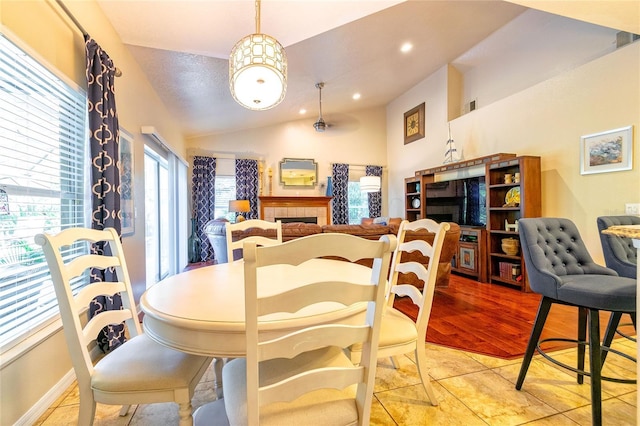 3509 Battersea Ct, Belle Isle, FL 32812 - dining space with vaulted ceiling, a tile fireplace, and recessed lighting