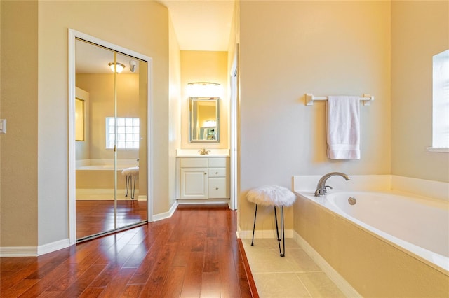 3509 Battersea Ct, Belle Isle, FL 32812 - bathroom featuring a bath, baseboards, vanity, and wood-type flooring