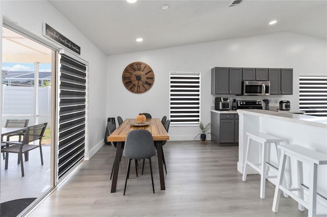 7803 Laurel Oak Ln, Kissimmee, FL 34747 - dining space featuring baseboards, light wood-type flooring, vaulted ceiling, and recessed lighting