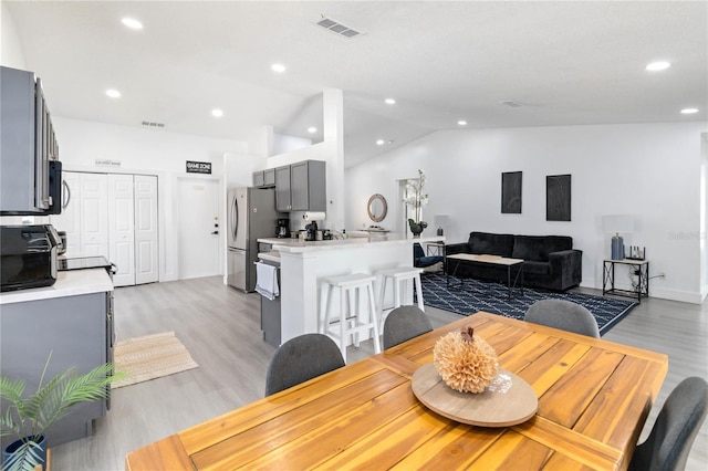 7803 Laurel Oak Ln, Kissimmee, FL 34747 - dining space with recessed lighting, lofted ceiling, light wood finished floors, and visible vents