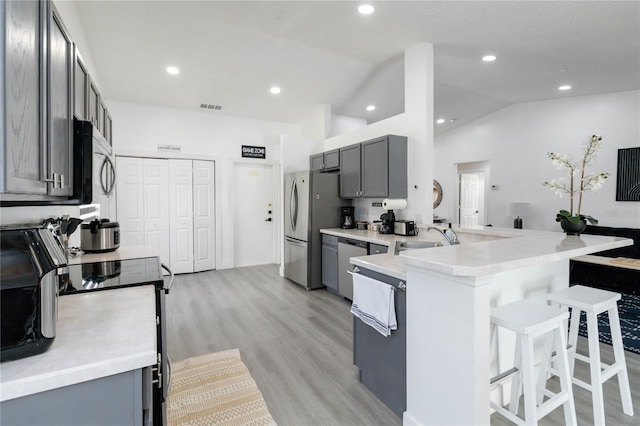 7803 Laurel Oak Ln, Kissimmee, FL 34747 - kitchen featuring visible vents, a breakfast bar, a sink, appliances with stainless steel finishes, and gray cabinetry