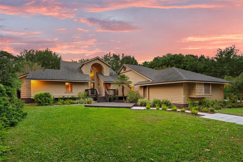 view of front of home featuring a yard and a wooden deck