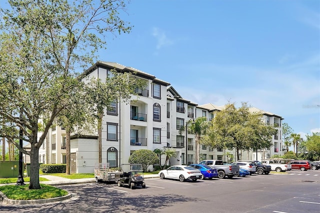 view of building exterior with uncovered parking and a residential view
