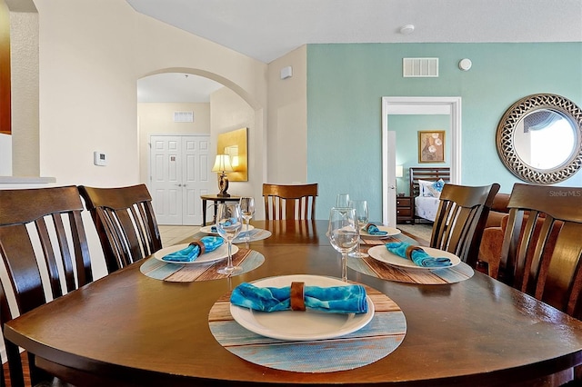 dining space featuring arched walkways and visible vents