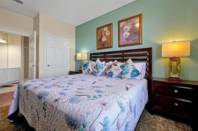 bedroom with ensuite bathroom and visible vents