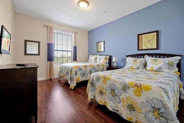 bedroom with baseboards and dark wood-style flooring