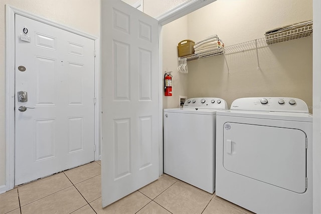 laundry room with washing machine and dryer, laundry area, and light tile patterned floors