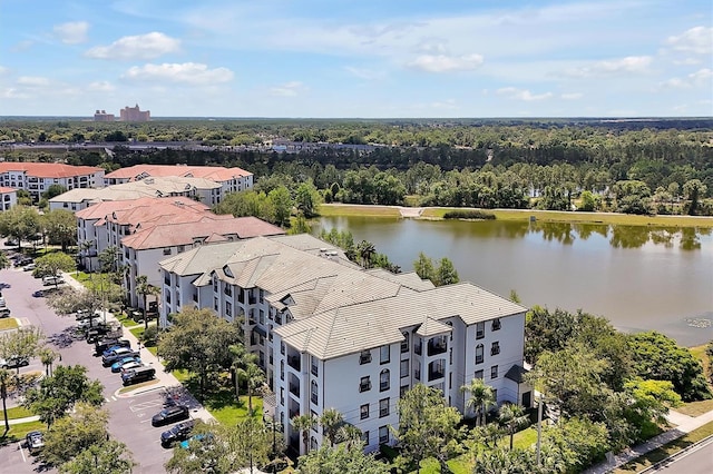 drone / aerial view with a wooded view and a water view