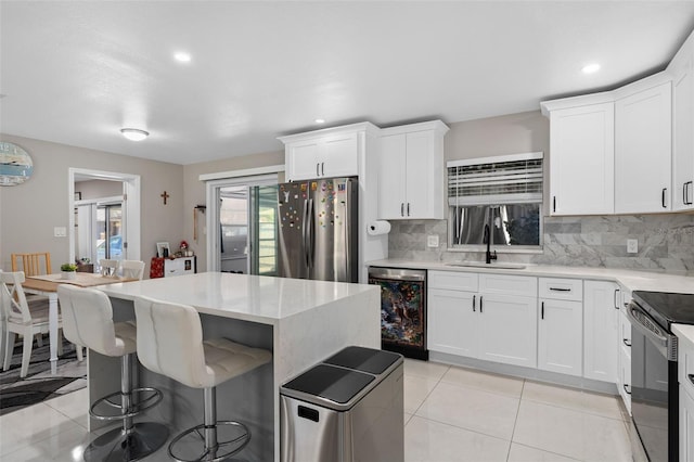 197 Flame Ave, Maitland, FL 32751 - kitchen featuring backsplash, dishwasher, a sink, freestanding refrigerator, and a kitchen bar