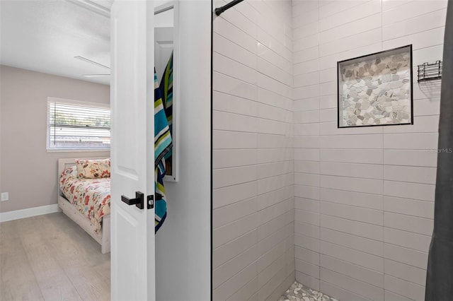 197 Flame Ave, Maitland, FL 32751 - bathroom featuring a tile shower, wood finished floors, baseboards, and ensuite bathroom