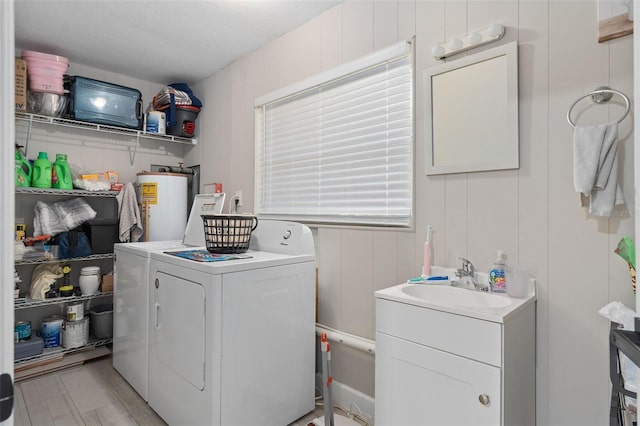 197 Flame Ave, Maitland, FL 32751 - clothes washing area with laundry area, a sink, light wood-style floors, gas water heater, and washer and dryer