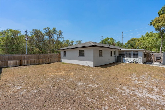 197 Flame Ave, Maitland, FL 32751 - rear view of property featuring central AC, a sunroom, concrete block siding, and a fenced backyard
