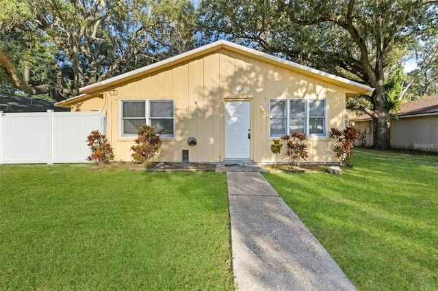 bungalow-style house featuring a front yard and fence