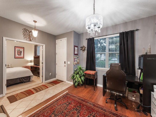 home office with an inviting chandelier, wood finished floors, and baseboards