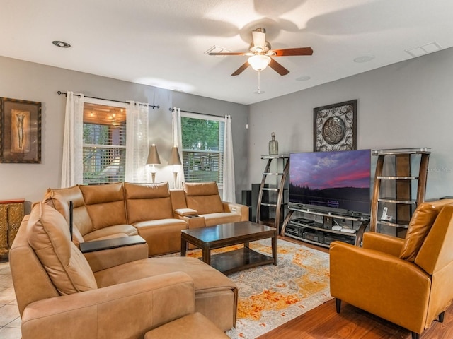 living room with ceiling fan, visible vents, and wood finished floors