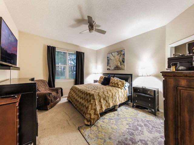 carpeted bedroom with ceiling fan and a textured ceiling