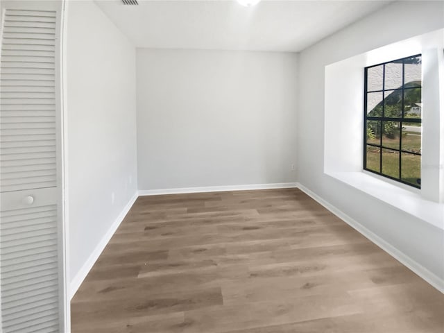 unfurnished room with baseboards and wood finished floors
