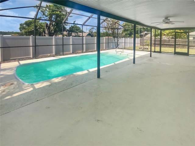 view of pool featuring a patio area, glass enclosure, a fenced backyard, a fenced in pool, and ceiling fan
