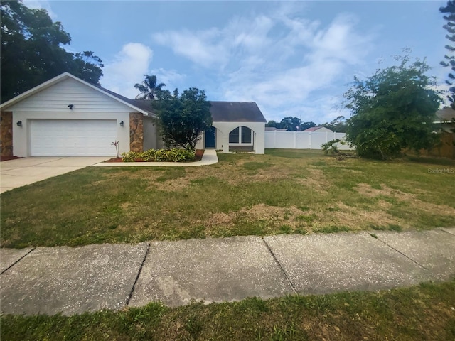 view of front of property with a front lawn, driveway, fence, an attached garage, and stucco siding