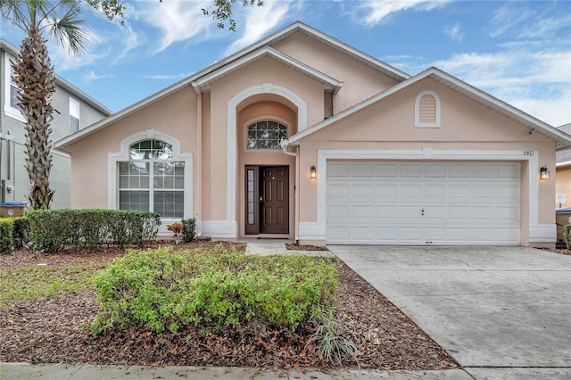 view of front of home featuring an attached garage, driveway, and stucco siding