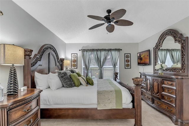 bedroom featuring ceiling fan, vaulted ceiling, a textured ceiling, and light tile patterned floors