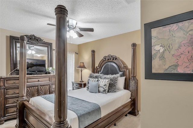 bedroom with a textured ceiling, light colored carpet, and ceiling fan