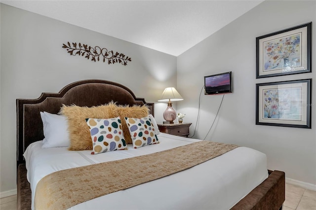 bedroom featuring vaulted ceiling, baseboards, and light tile patterned floors