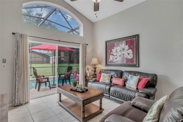 living room with a high ceiling, a ceiling fan, and light tile patterned floors