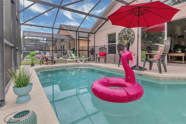 outdoor pool featuring a patio area and glass enclosure