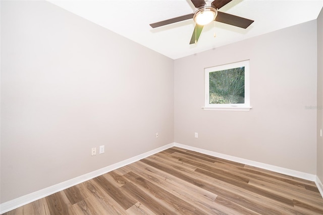unfurnished room featuring baseboards, wood finished floors, and ceiling fan