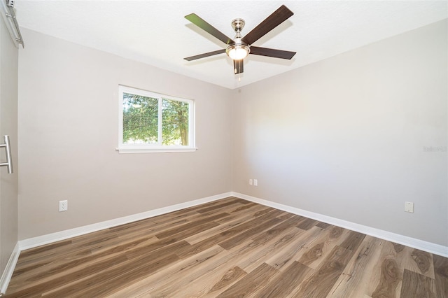 unfurnished room featuring wood finished floors, baseboards, and a ceiling fan