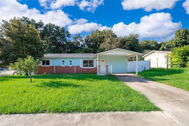 single story home featuring a front yard, fence, brick siding, driveway, and an attached carport