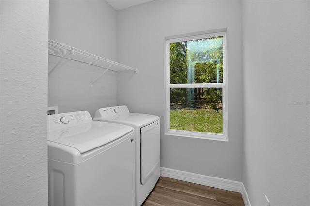 clothes washing area featuring laundry area, dark wood-style flooring, baseboards, and washing machine and dryer