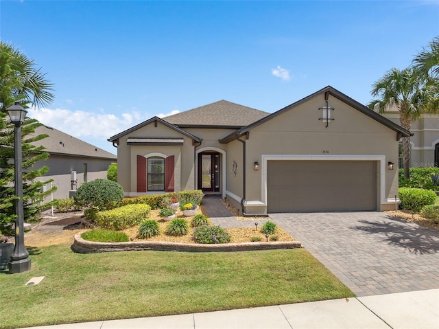 2530 Stargrass Cir, Clermont, FL 34715 - view of front of home featuring stucco siding, an attached garage, decorative driveway, and a front lawn