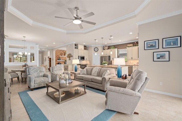 2530 Stargrass Cir, Clermont, FL 34715 - living room featuring a tray ceiling, recessed lighting, ceiling fan with notable chandelier, ornamental molding, and light tile patterned floors