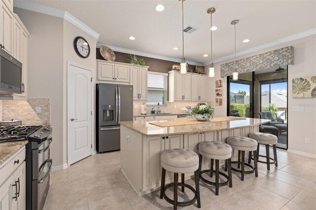2530 Stargrass Cir, Clermont, FL 34715 - kitchen featuring a sink, visible vents, backsplash, a kitchen island, and appliances with stainless steel finishes