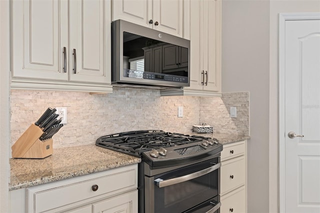 2530 Stargrass Cir, Clermont, FL 34715 - kitchen featuring backsplash, white cabinetry, light stone counters, and stainless steel appliances