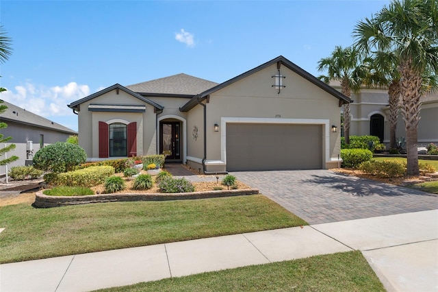 2530 Stargrass Cir, Clermont, FL 34715 - view of front of house with a garage, a front yard, stucco siding, and decorative driveway
