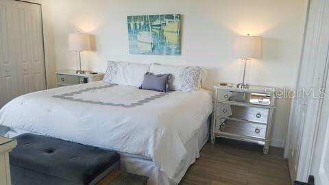 bedroom featuring a closet and dark wood-style flooring