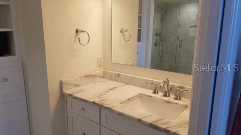 full bathroom with a shower stall and vanity