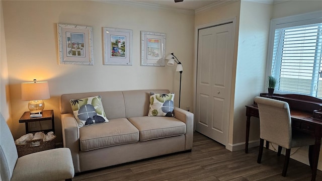 living area with baseboards, ornamental molding, and wood finished floors