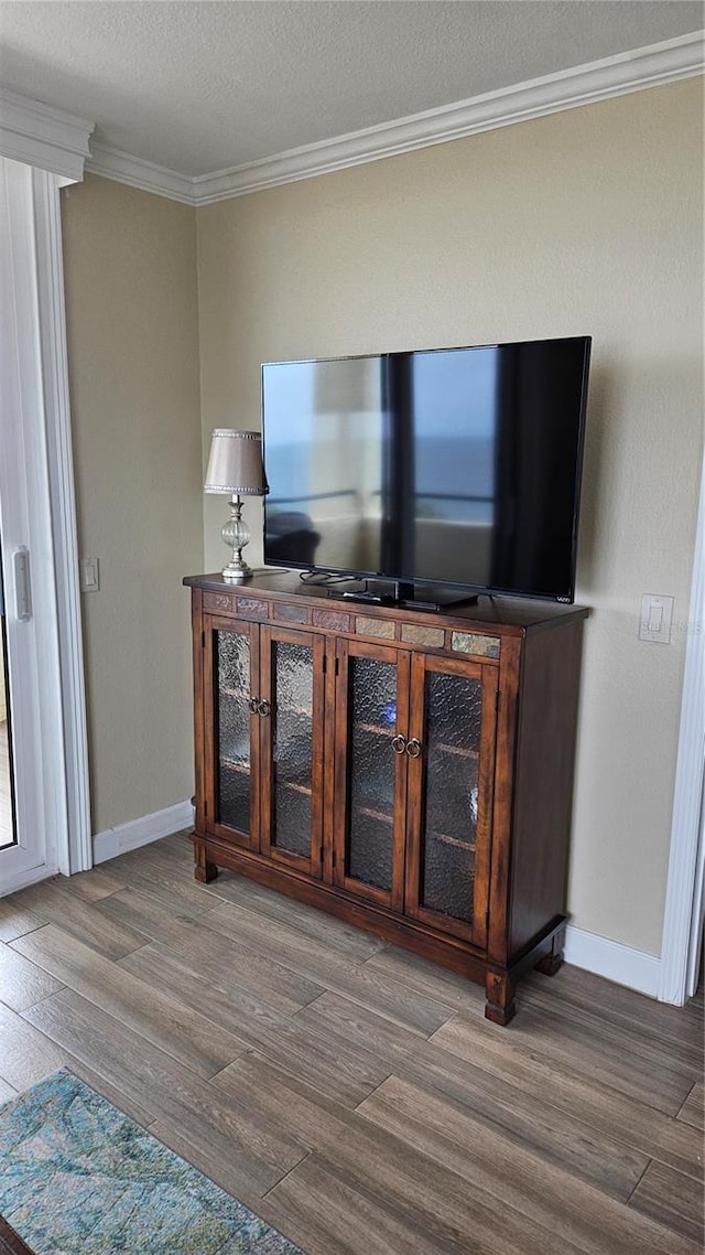 interior details featuring crown molding, baseboards, and wood finished floors